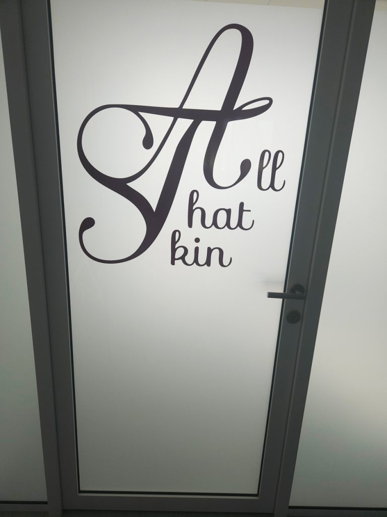 Entree van All That Skin met het logo op de deur